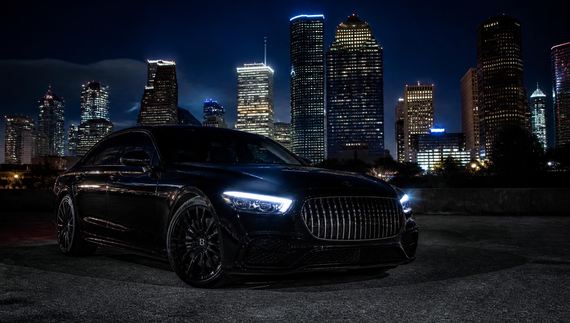 Luxury car with bright headlights against the Houston skyline at night